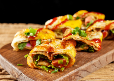 木桌上餐具上摆放的东北烤冷面