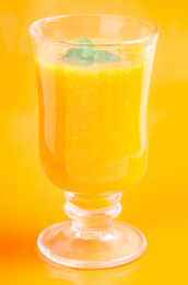 黄色背景上放着一杯鲜榨芒果果汁