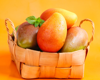 彩色背景上放着一篮贵妃芒果和贵妃芒果果肉