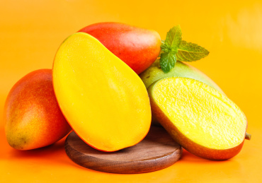 彩色背景上放着贵妃芒果和贵妃芒果果肉