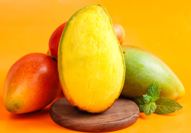 彩色背景上放着贵妃芒果和贵妃芒果果肉