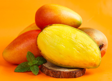 彩色背景上放着贵妃芒果和贵妃芒果果肉