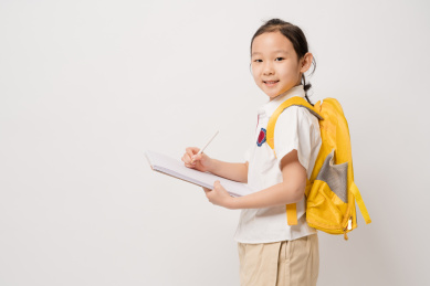 白色背景在作业本书上写的中国女孩