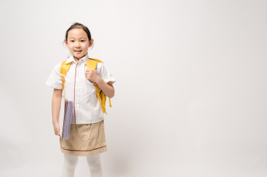 站在白色背景拿着作业本的中国女孩