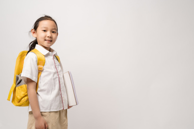 站在白色背景拿着作业本的中国女孩