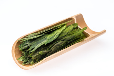 白底背景上竹器里的太平猴魁茶叶