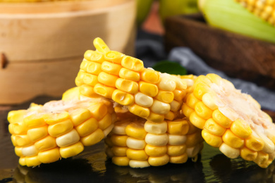 黑底上放着切开的甜玉米