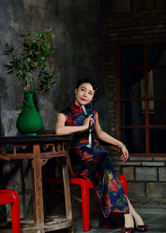 穿着旗袍女人坐在一所老房子里