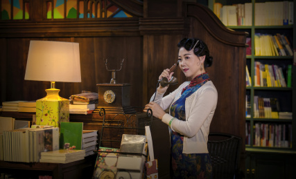 穿着旗袍的女人在一座老房子里打电