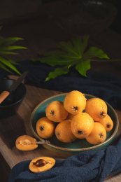 放在木桌上的一盘枇杷