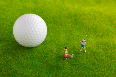 草地上高尔夫球旁的青年男女