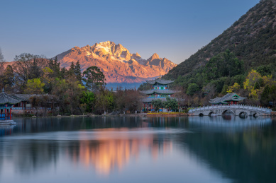 中国云南丽江黑龙潭公园视角的玉龙雪山日出