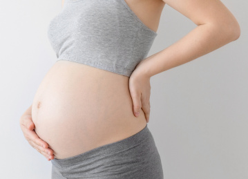 年轻孕妇撑着腰部