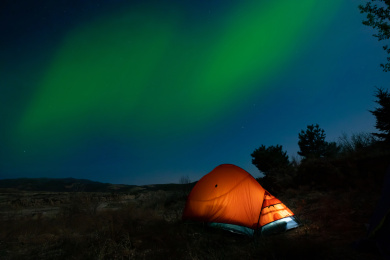 北极光星空下的桔色帐篷