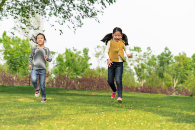 夏天在公园草坪上奔跑中国女孩