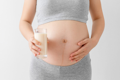 孕妇手里拿着一杯牛奶