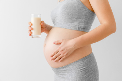 孕妇手里拿着一杯牛奶