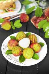 黑底上放着一盘妃子笑荔枝和荔枝果肉