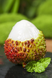 黑底上放着一颗剥开的妃子笑荔枝