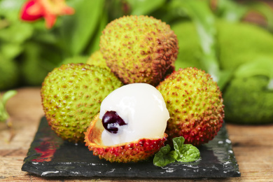 黑底上放着一堆新鲜妃子笑和妃子笑果肉 