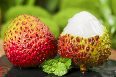 黑底上放着新鲜妃子笑和妃子笑果肉