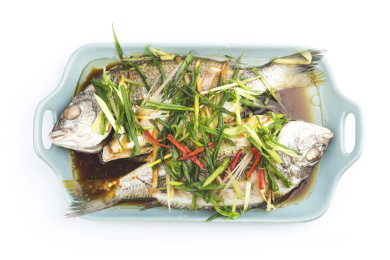 木桌背景中的一盘清蒸花雕鱼