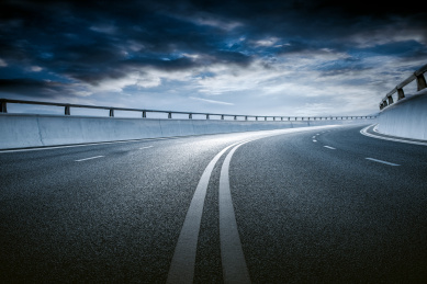 晴朗蓝天白云为背景，高速公路立交桥弯曲引桥