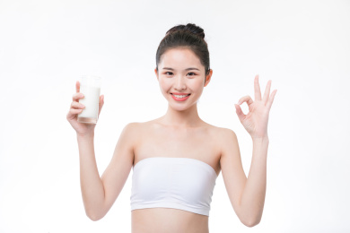 女生拿着一杯牛奶微笑