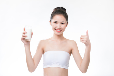 女生拿着一杯牛奶微笑