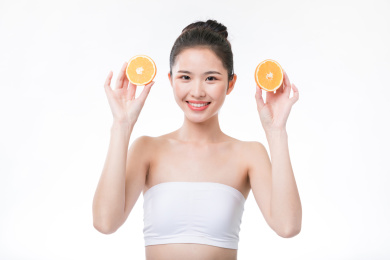 女生双手拿橙子