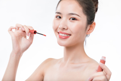 拿着唇釉化妆的女性