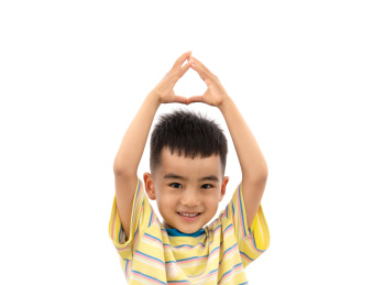 一个可爱的儿童双手举过头顶做出比心的动作