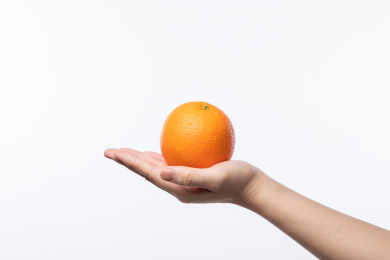 白色背景特写手拖着一个橙子
