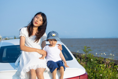 夏天年轻妈妈和小孩子在一起吹海风