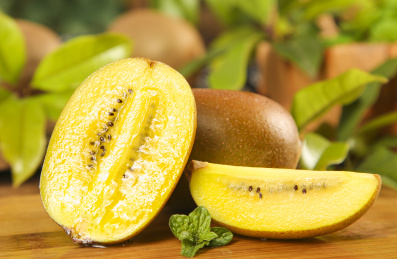 木底上放着黄心猕猴桃和猕猴桃果肉