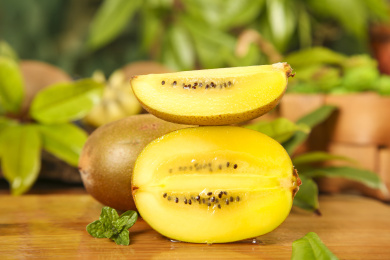木底上放着黄心猕猴桃和猕猴桃果肉