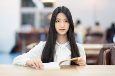 漂亮的女生坐在图书馆看书
