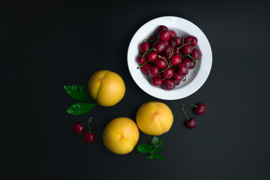 桃子和樱桃放在白色餐盘中