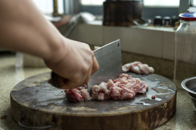 一位厨师在剁猪肉碎肉