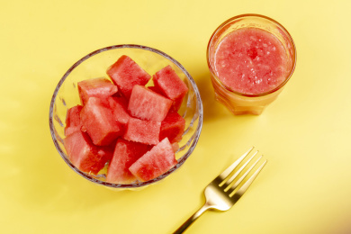 黄色背景上夏季水果西瓜块西瓜汁特写