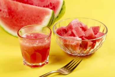 黄色背景上夏季水果西瓜块西瓜汁特写