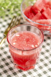 格子桌布上夏季水果一杯西瓜汁特写