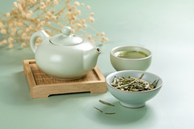 绿茶西湖龙井茶摆放在绿色背景上