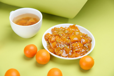 金橘果茶和金桔放在绿色背景上