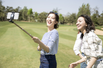 女孩们拿自拍杆拍照
