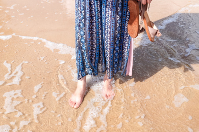 女孩光着脚在海边沙滩上