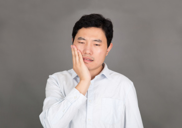 牙疼捂着脸的年轻男士