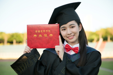 穿着学士服的毕业生手拿毕业证微笑
