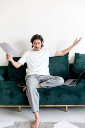 客厅里一位崩溃的年轻男人和散落一地的报表