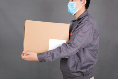 戴着口罩的年轻快递员在送快递